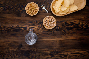 empty beer glass and snack on wood background. top view. copy space