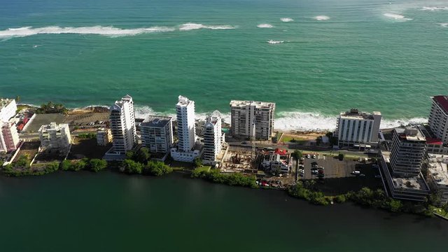4k Drone aerial flyover of the Peninsula De Condado that shows some highrise buildings along a thin trip of land in Old San Juan Puerto Rico.