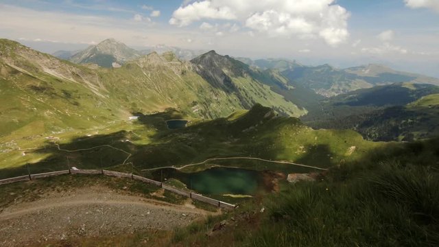 Camera moving over rocky ground to reveal beautiful mountain landscape with lake near Champery, Switzerland