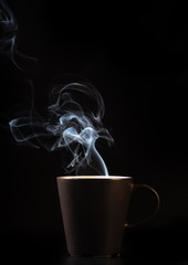 coffee brown mug and smoke on black background
