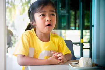 Portrait asian children of girl Eating cake in birthday.