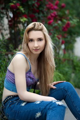 Obraz premium Beautiful sexy young blond woman in torn jeans posing on the streets of the old town
