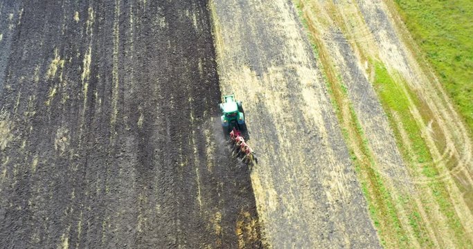 Aerial view drone of harvest field with tractor mows dry grass. Autumn yellow field with a haystack after harvest top view. Harves. Ting in the fields. 