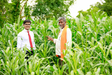 Obraz na płótnie Canvas Indian farmer and agronomist checking and Discuss at Green Corn Field