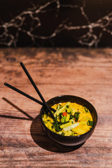 vegan singapore noodles with veggies and warm curry soup bowl with chopsticks