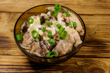 Marinated carp in glass bowl on wooden table