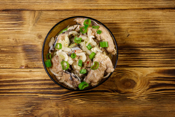 Marinated carp in glass bowl on wooden table. Top view