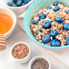 Bowl of buckwheat porridge with blueberry on vintage table top view in flat lay style. Hot breakfast and homemade food