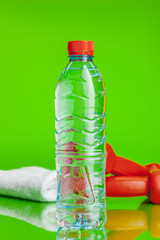 Crystal clear water in a bottle on green background