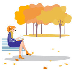 A young woman sitting on a bench reading a book in the autumn Park.