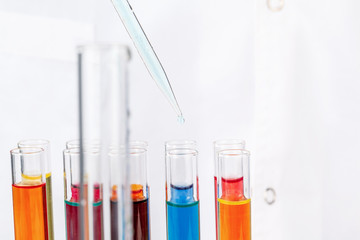 Chemist hands holding test tubes with liquids and doing experiments
