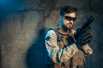 American private military contractor holding rifle. Image on a dark background