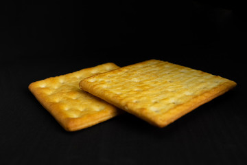 Cracker cookies on dark background.