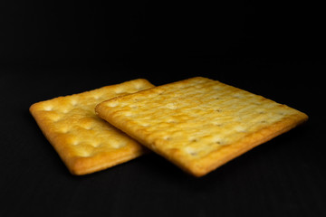 Cracker cookies on dark background.