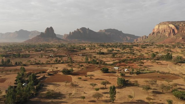 Africa desert landscapes - drone flight of rural fields and small village community in surreal mountain setting, agriculture and scenery in Tigray region in Ethiopia