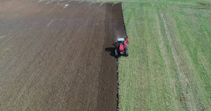 Aerial view drone of harvest field with tractor mows dry grass. Autumn yellow field with a haystack after harvest top view. Harves. Ting in the fields. 