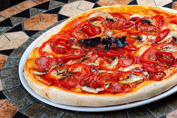 Diabola pizza with chorizo and chili. Spicy dish. On the stone table