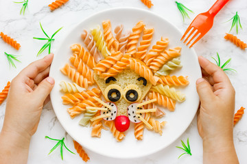 Fun food idea for kids lunch, animal shaped food art - colorful fusilli vegetables pasta with...