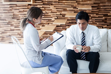 女性カウンセラーと話をする男性社員