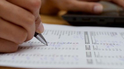 Closeup shot of a chartered accountant checking company balance sheet . 
