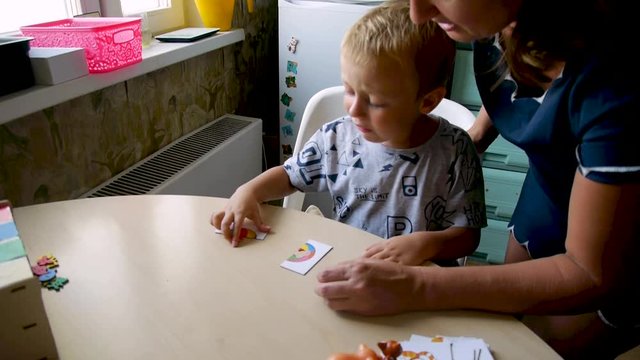 autistic child is naughty while completing a teacher's assignment - collecting a puzzle 