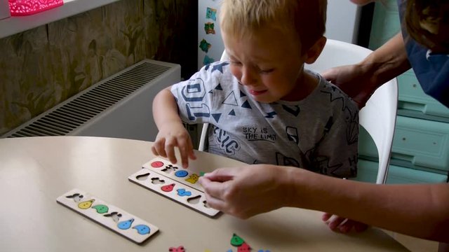 an autistic child is naughty and hardly fulfills the tasks of an assistant - collects puzzles in forms