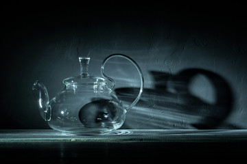 empty glass teapot on black background in spot light