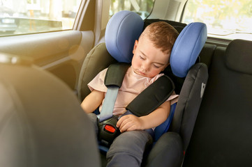 Sleeping baby boy buckled in car seat