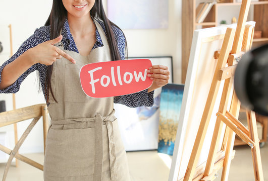 Female Asian blogger recording video in workshop