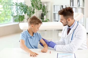 Doctor vaccinating little boy in clinic