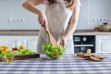 Diet. young pretty woman in green shirt standing and preparing the vegetables salad in bowl for good healthy in modern kitchen at home, healthy lifestyle, cooking, healthy food