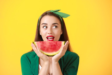 Beautiful young woman with slice of fresh watermelon on color background