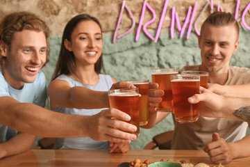Friends drinking fresh beer in pub