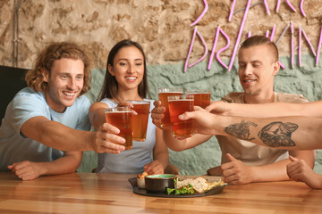 Friends drinking fresh beer in pub