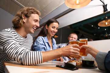 Friends drinking fresh beer in pub