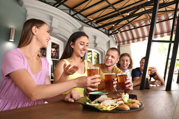 Friends drinking fresh beer in pub