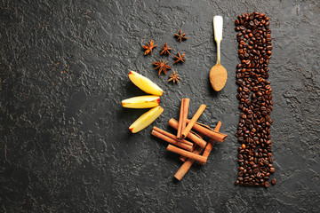 Aromatic cinnamon with coffee beans, anise and apple slices on dark background