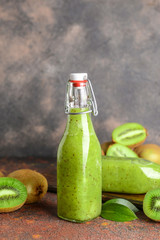 Bottle of tasty kiwi smoothie on table