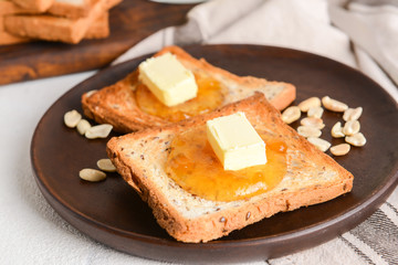 Tasty toasted bread, butter and jam on plate