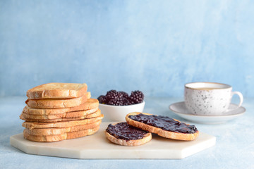 Board with tasty toasted bread and jam on table