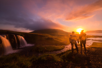 Fototapeta premium Silhouette of Couple enjoy view Kirkjufellsfoss at morning, summer in Iceland