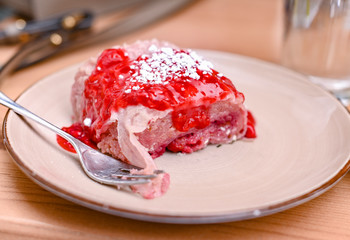 Traditional Slovenian dessert made of dough, cheese and fruit. Dumplings with raspberries for a delicious breakfast in a European cafe.