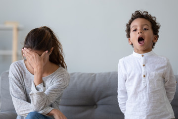 Stressed upset mother tired about stubborn african kid son tantrum