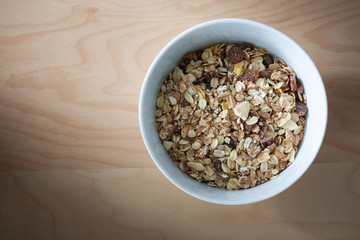 Bowl of muesli isolated on wood table background, Top view