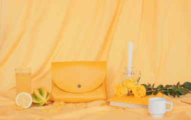 yellow objects: bag, book, lemon, candy, flowers on a yellow background. fabric background, layout, place for text. design