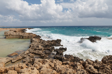 Rocky sea shore with splaches of waves. Cyprus - Mediterranean Sea coast.