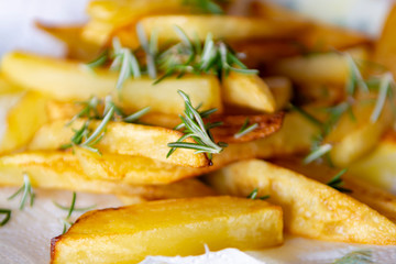 Golden fried potatoes chips  with fresh aromatic rosemary herb