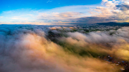 View from a drone flying over a cloud in the morning With the mountainous environment.
