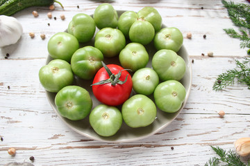green tomatoes,pickles background on white wooden table with green and red and chilli peppers,fennel,salt,black peppercorns,garlic,pea,close up,healthy concept,top view,flat lay