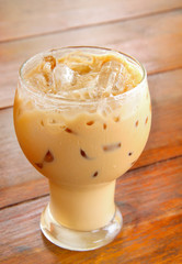 Thai iced coffee in glass on brown wood table closeup fresh organic background